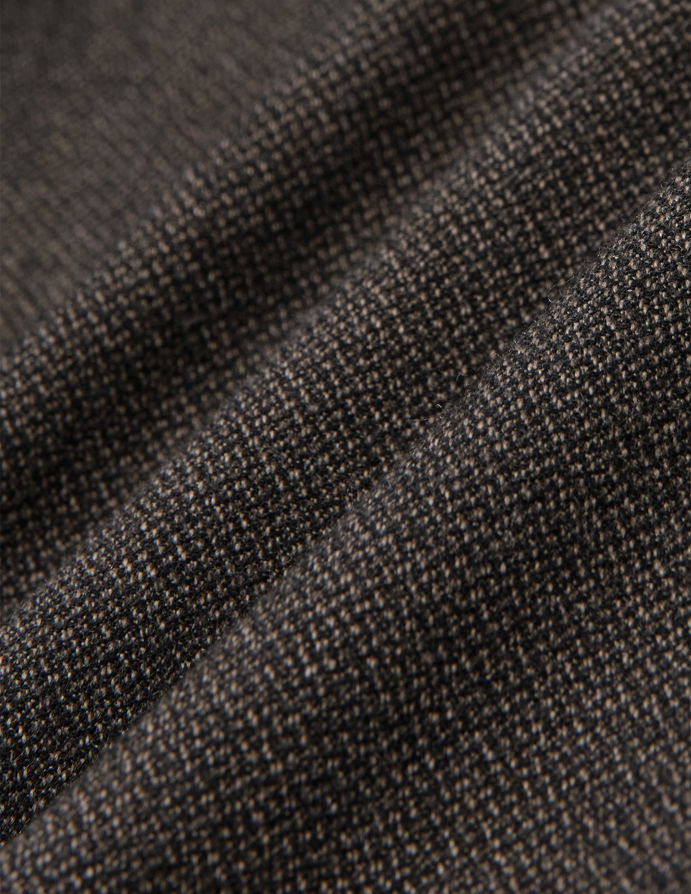 Nærbilde av Atelier Pants Relaxed Dark Brown i brettet mørkebrunt stoff med et strukturert, brutt twill-vev.